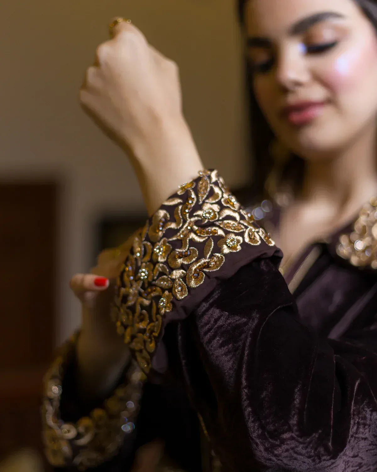Close-up of the elegant bronze and gold embroidered cuffs on the brown velvet caftan.
