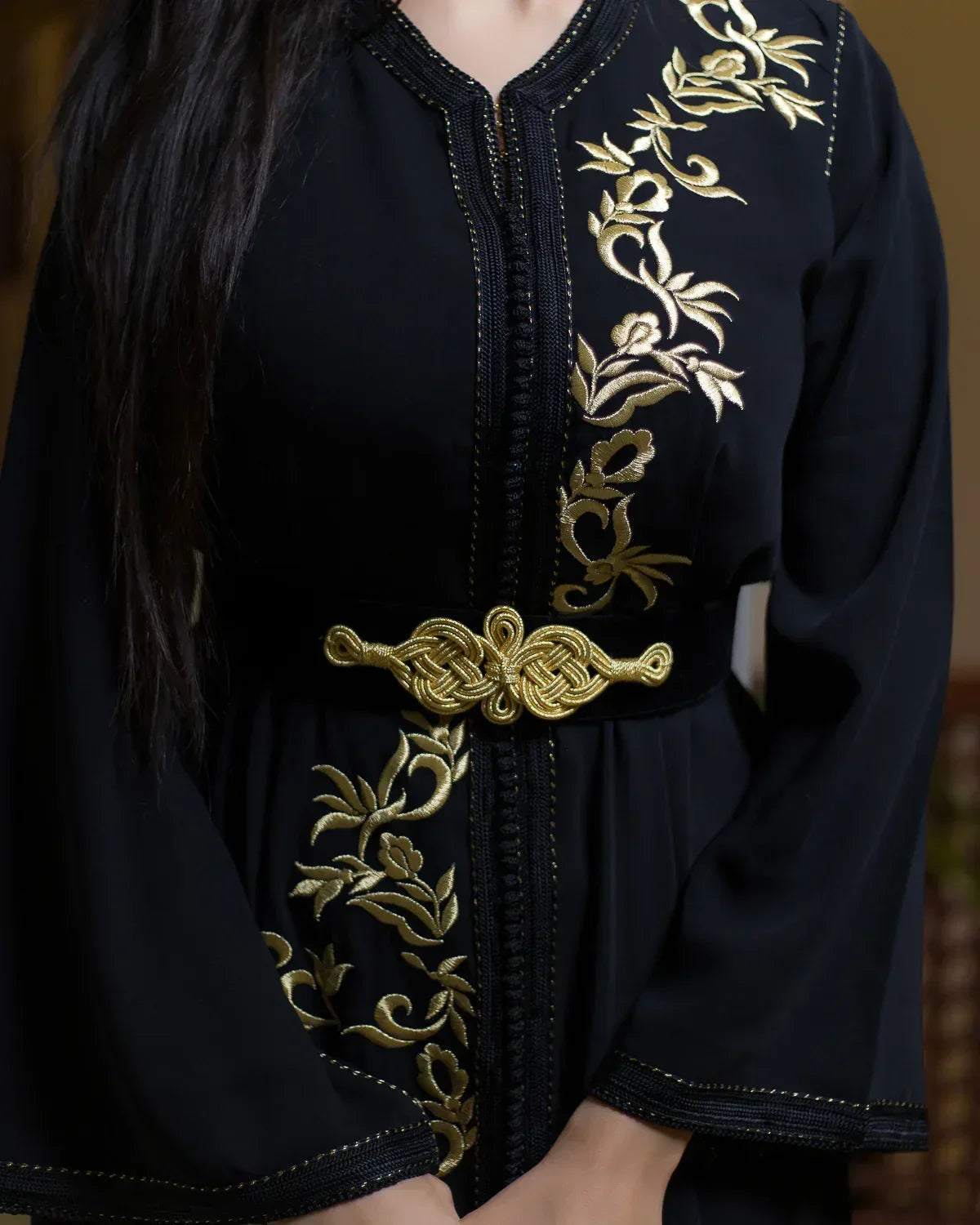 Close-up of the elegant golden knot belt and torso embroidery on black caftan