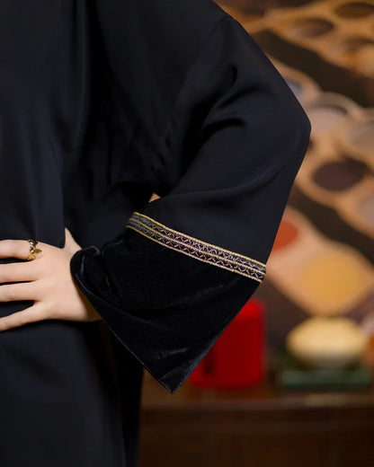 Detailed view of the wide black velvet sleeve cuff with elegant gold patterned trim on the crepe kimono.