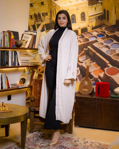 Full length front view of WATAR Harmony beige kimono styled with black trousers and gold heels.