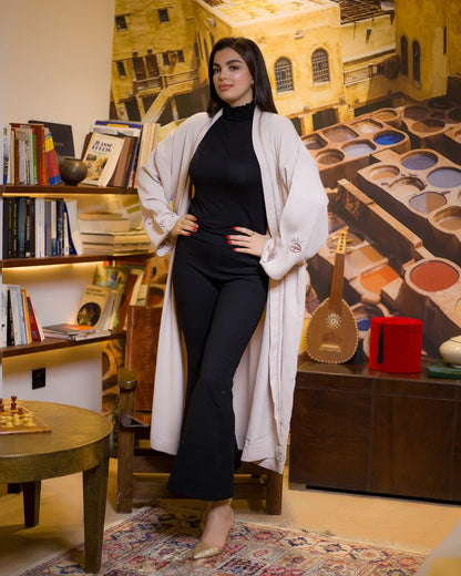 Model posing in WATAR Harmony beige kimono with hands on hips, showcasing the wide embroidered sleeves.