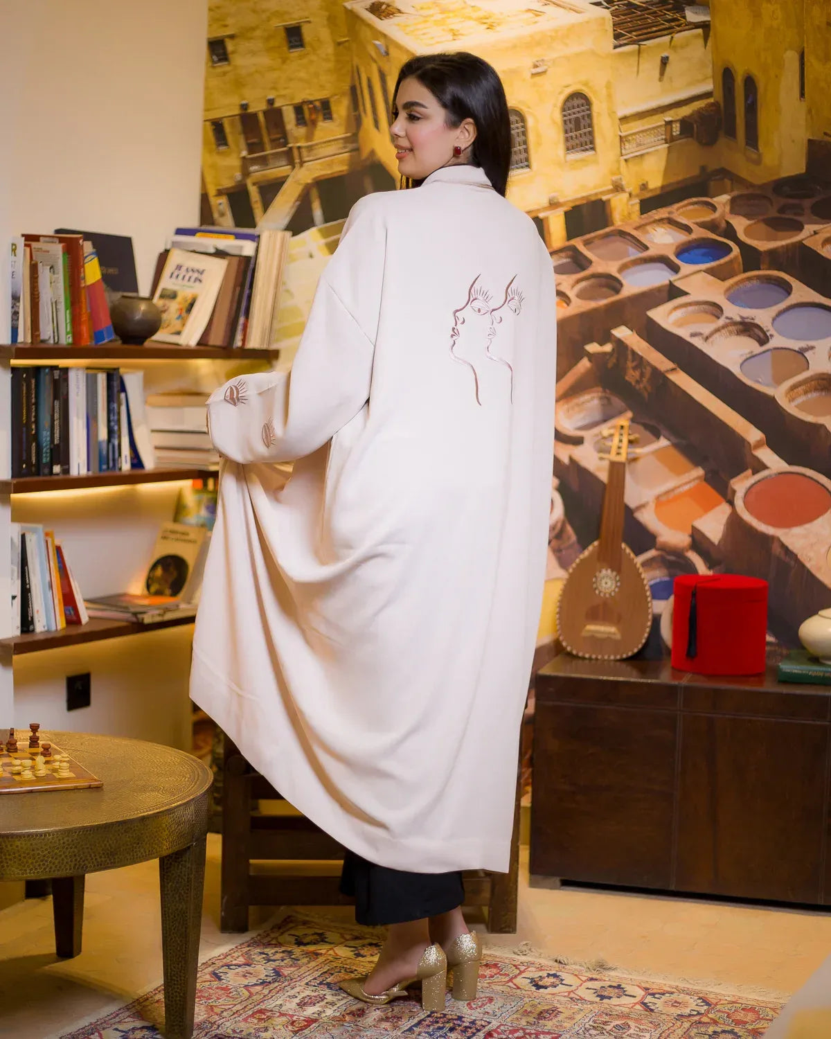 Back view of WATAR Harmony beige kimono showing artistic face embroidery and oversized fluid fit.