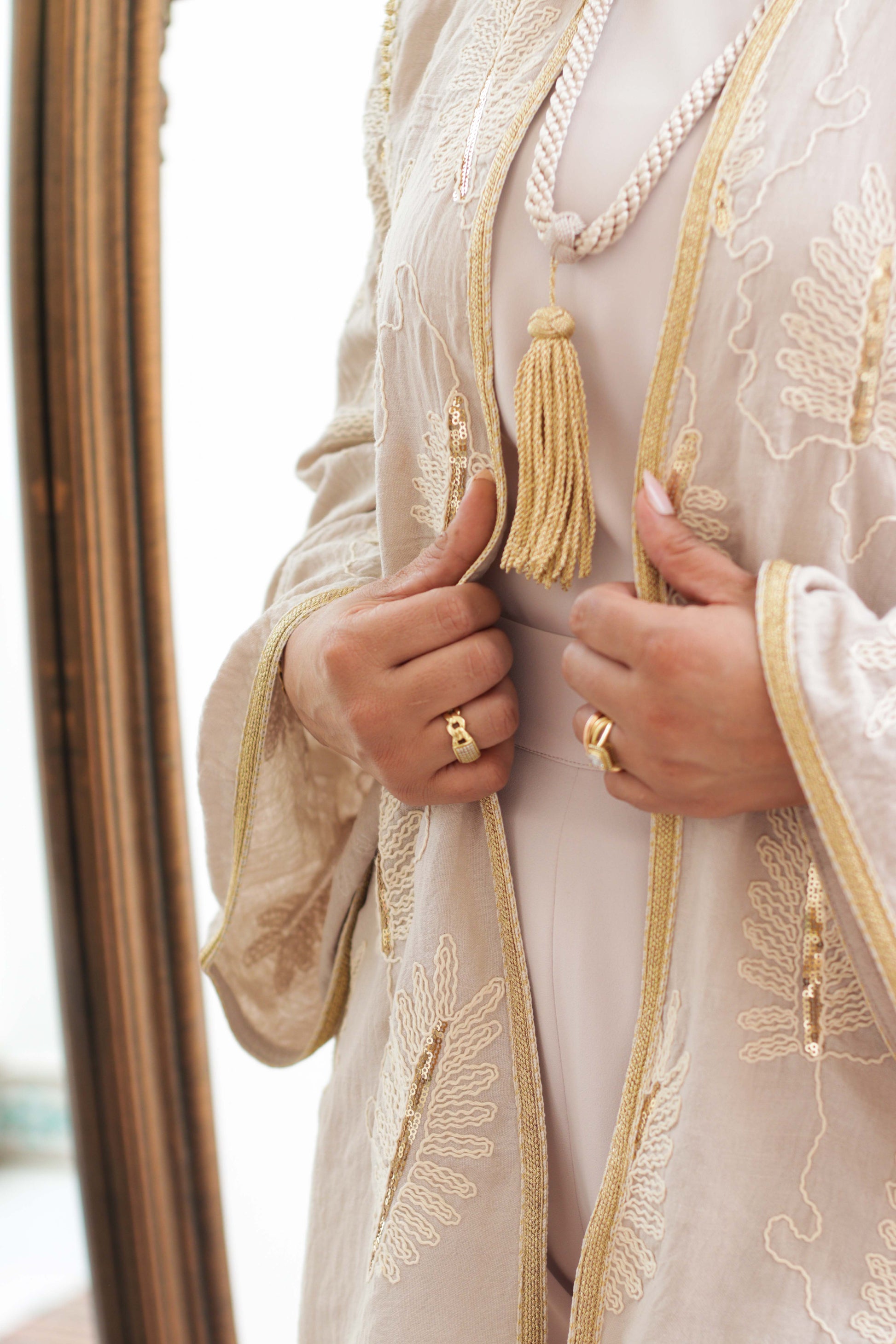 Détail des finitions bronze et du tissu crêpe Corée sur le kimono court beige Oud	