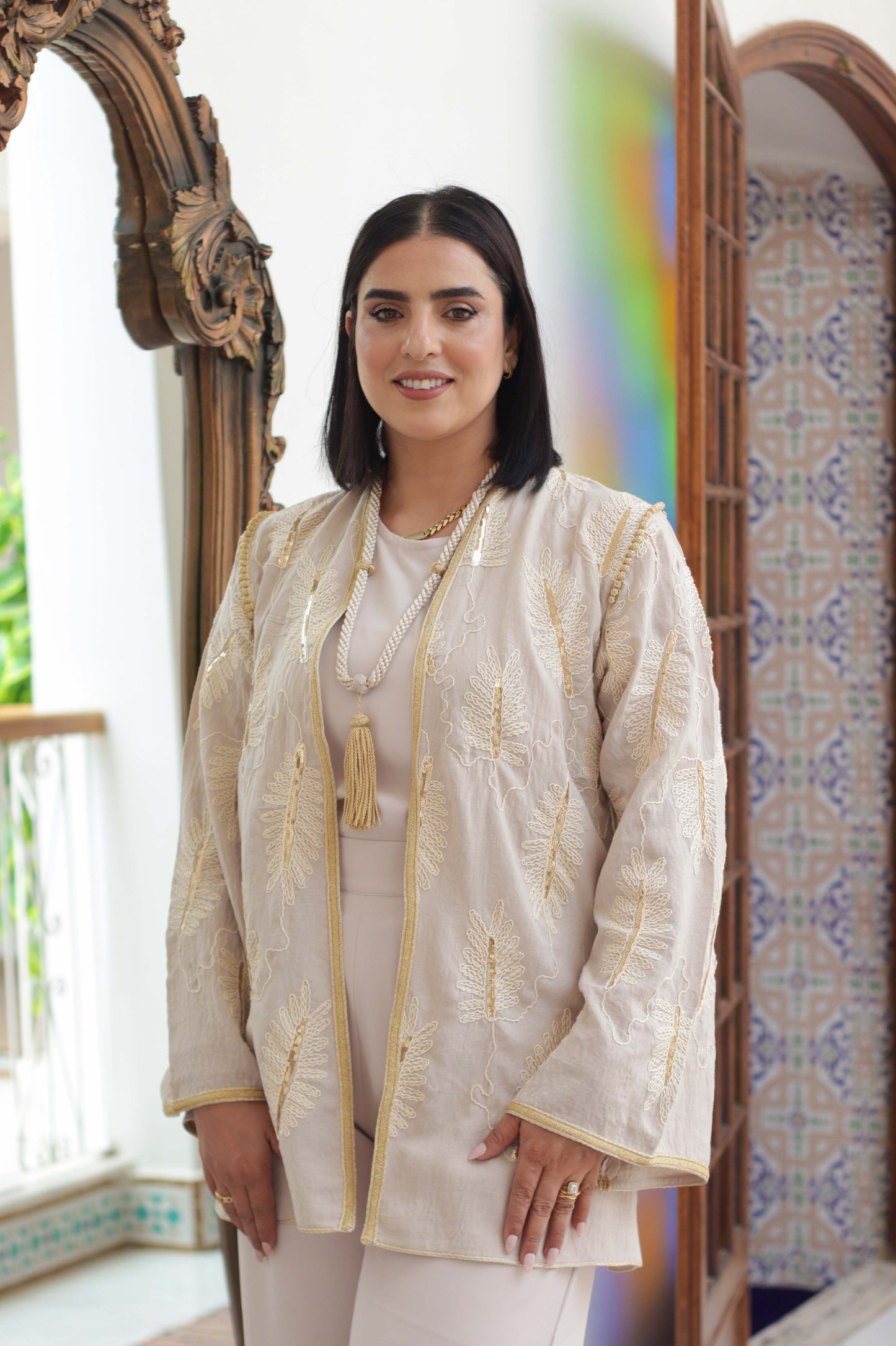 Gros plan du kimono marocain beige Oud avec broderie feuille en bronze et pompon Majdoul	