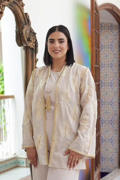Gros plan du kimono marocain beige Oud avec broderie feuille en bronze et pompon Majdoul	